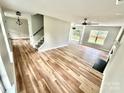 Open-concept living room features light wood flooring, fireplace, modern lighting, and lots of natural light at 2242 Shumard Cir, Indian Trail, NC 28079