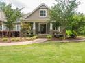 Inviting front porch with stone accents, a walkway through manicured garden beds, and mature trees at 237 Garvin Rd, McConnells, SC 29726