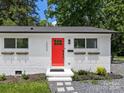 Charming home featuring a bright red door, brick exterior, and well-manicured landscaping at 2600 Alleghany St, Charlotte, NC 28208