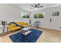 Bright living room with a yellow sofa, a dark blue rug, and hardwood floors at 2600 Alleghany St, Charlotte, NC 28208