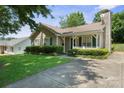 Charming single-story home with well-manicured lawn and cozy front porch with white picket fence at 322 Cottonwood Park Dr, Charlotte, NC 28214