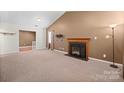 Spacious living room with neutral carpet, fireplace, and ample natural light through sliding windows at 322 Cottonwood Park Dr, Charlotte, NC 28214