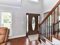 Bright foyer with hardwood floors and staircase, showcasing a decorative front door at 3905 Brittany Ct, Indian Trail, NC 28079
