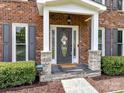 Close up of front entrance with stone accents and welcoming door wreath at 3905 Brittany Ct, Indian Trail, NC 28079