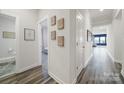 Bright hallway with hardwood floors leading to bedrooms and bathrooms, adorned with framed maps at 4420 Bright Rd, Charlotte, NC 28214