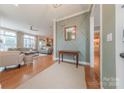 Stylish entryway featuring textured wall, hardwood floors, mirror, and seamless flow into the living area at 5256 Meadowcroft Way, Fort Mill, SC 29708