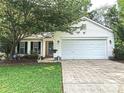 Inviting home with a well-maintained lawn, mature trees, and a two-car garage enhancing curb appeal at 5434 Starflower Dr, Charlotte, NC 28215