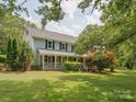 Traditional home featuring a covered front porch, well-kept lawn, and lush landscaping at 5632 Zion Church Rd, Concord, NC 28025