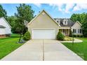 Exterior shot of the home's facade, featuring a wide garage and well-manicured landscaping at 6530 Fly A Way Dr, Denver, NC 28037