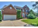 Charming two-story brick home with well-kept lawn and an attached two-car garage at 6873 Lakecrest Ct, Denver, NC 28037