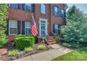 Inviting brick porch with decorative landscaping and an American flag at 6873 Lakecrest Ct, Denver, NC 28037