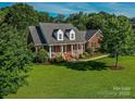 A charming red brick home featuring a well-manicured lawn and a welcoming front porch with white columns at 908 Haddonfield Dr, Fort Mill, SC 29708