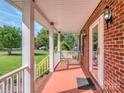 Cozy front porch featuring a swing, brick accents, and views of the surrounding greenery at 908 Haddonfield Dr, Fort Mill, SC 29708