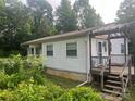 Exterior view of home showing siding, porch with pergola, and overgrown shrubbery at 9314 Seymour Ln, Davidson, NC 28036