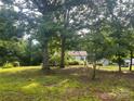 Exterior view of home showing it set back from the street among mature trees at 9314 Seymour Ln, Davidson, NC 28036