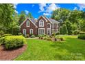 Charming brick home with lush green lawn and mature trees, showcasing classic architectural details at 9514 Hayenridge Ct, Huntersville, NC 28078