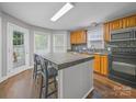 Bright kitchen featuring an island, natural wood cabinets, and modern appliances at 1015 Rhode Island Ave, Kannapolis, NC 28083