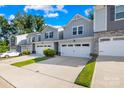 Townhome exterior with gray siding, stone accents, and a two-car garage at 1022 Maltby St, Charlotte, NC 28217