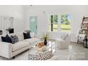 Bright living room with a modern interior design and comfortable white furniture with pops of color at 103 Wadesborough Pl, Wadesboro, NC 28170