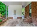 A covered carport area with an enclosed storage and brick steps at 1332 Midwood Dr, Gastonia, NC 28052