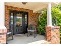 Inviting front porch with rocking chairs, black door, and brick pillars at 139 Hardwick Dr, Mooresville, NC 28115