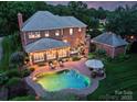 Aerial view of the backyard featuring a kidney-shaped pool, outdoor seating, and lush landscaping, perfect for entertaining at 159 Carsons Pl, Mooresville, NC 28117