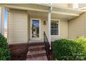 Charming home exterior featuring a covered entryway with brick steps and lush green bushes at 1670 Robins Nest Ct # D, Gastonia, NC 28054