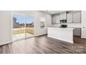 Bright kitchen with white cabinets, stainless steel appliances, and sliding glass doors to the backyard at 2125 Rolling Hills Ct, Stanley, NC 28164