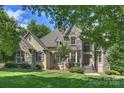 Beautiful stone-and-stucco home with manicured lawn, mature trees and covered front entry at 3284 Millstone Creek Rd, Lancaster, SC 29720