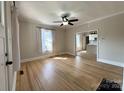 Bright living room featuring hardwood floors, ceiling fan, and view into kitchen at 339 Mayflower Ave, Cramerton, NC 28032