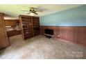 Cozy living room with unique wood paneling, built-in bookshelves, and easy kitchen access at 34393 Springdale Dr, New London, NC 28127