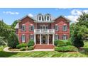 Charming brick home with white balcony and manicured landscaping at 3706 Song Sparrow Dr, Matthews, NC 28104