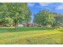 Expansive front yard with mature trees framing the charming one-story brick home at 37156 Southside Rd, Albemarle, NC 28001