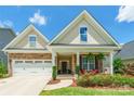 Charming home with a well-manicured lawn, stone accents, covered front porch, and bright landscaping at 385 Willow Tree Dr, Rock Hill, SC 29732