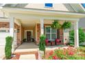Inviting covered porch with brick columns, hanging ferns, and seating perfect for relaxing at 385 Willow Tree Dr, Rock Hill, SC 29732