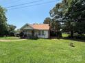 A well-maintained lawn surrounds a quaint home with a inviting front porch at 4059 10Th Avenue Sw Dr, Hickory, NC 28602