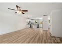 Open living room with hardwood floors flows seamlessly into the kitchen with white cabinetry at 443 Faith Sw Dr, Concord, NC 28027