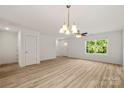Sun-drenched living room with hardwood floors, modern lighting, and a view to the front entrance at 443 Faith Sw Dr, Concord, NC 28027