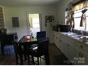 View of kitchen with white cabinets, stainless steel sink, and dining table at 448 Belk St, Lancaster, SC 29720