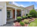 Charming front porch featuring brick accents, white columns, and meticulous landscaping at 5238 Prosperity View Dr, Charlotte, NC 28269