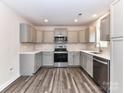 Well-lit kitchen showcasing gray cabinetry, stainless steel appliances, and sleek countertops, creating an inviting culinary space at 5306 Lee Massey Rd, Waxhaw, NC 28173