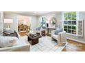 Cozy living room featuring plush seating, natural light, and seamless flow into the adjacent dining area at 6150 Rocky Falls Rd, Charlotte, NC 28211
