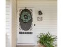 Close up of the home's inviting front door with decorative wreath, stylish light fixture, and house number at 6934 Loretta Pl, Charlotte, NC 28215