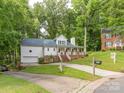 Charming two-story home with a welcoming front porch and well-maintained landscaping in a lush, green neighborhood at 6934 Loretta Pl, Charlotte, NC 28215