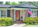 Inviting front entrance with a red door, decorative ironwork, and an American flag waving in the breeze at 7026 Tabor Ln, Charlotte, NC 28211