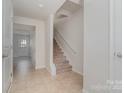 Hallway view featuring tiled flooring, a staircase with carpeted steps, and neutrally painted walls at 706 Dillon Way, Fort Mill, SC 29715