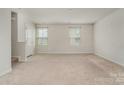 Living room with carpet flooring, two windows for natural light, and neutral paint at 706 Dillon Way, Fort Mill, SC 29715