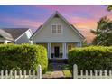 Charming yellow home featuring a gabled roof, inviting front porch with white columns and beautiful landscaping at 7344 Gilead Rd, Huntersville, NC 28078