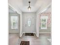 Inviting foyer with wood-look flooring, white trim, and a classic pendant light, offering a glimpse into adjacent rooms at 7639 Winterset Dr, Charlotte, NC 28270