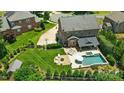 Aerial view of landscaped backyard featuring a pool, fire pit, and basketball court at 7903 Tottenham Ct, Waxhaw, NC 28173